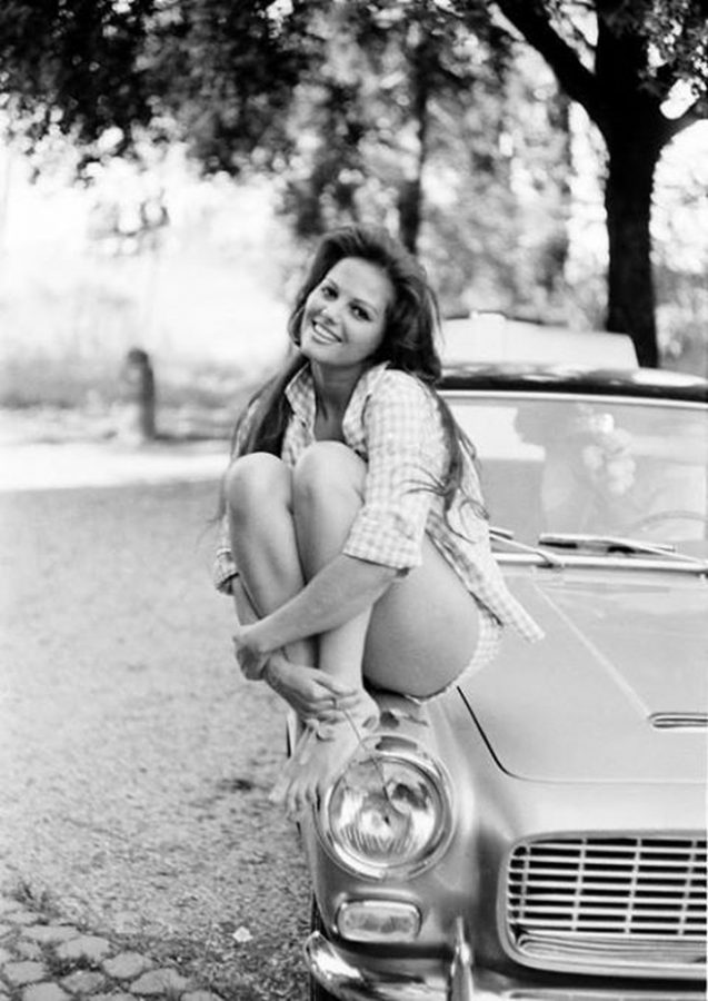 Claudia Cardinale sits on a car